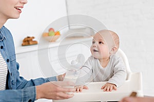 mother feeding little baby boy with milk