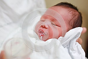 Mother feeding milk infant baby by glass cup