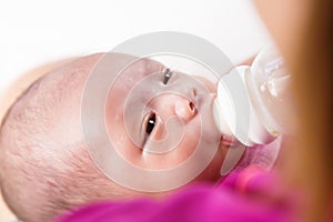 Mother feeding newborn baby boy with milk in nursing bottle