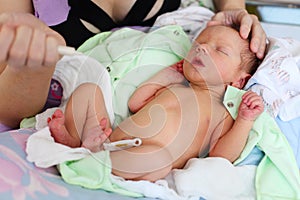 Mother feeding newborn baby milk with syringe