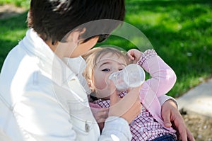 Mother feeding one year baby girl with feeding bottle