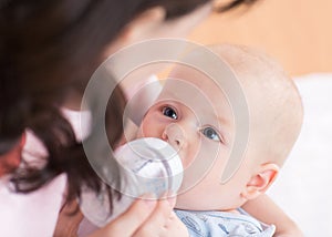 Mother feeds her baby from bottle