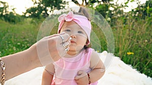 Mother feeds her little daughter with yogurt