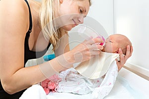 mother feeds their infant baby with bottle photo