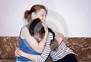 A mother feels sorry for her daughter as a teenager, holding her close and hugging her