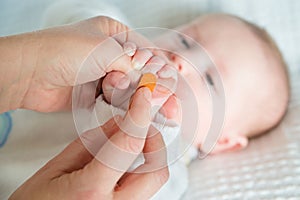 Mother filing and smoothing baby's fingernails