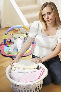 Mother Folding Baby Clothes At Home