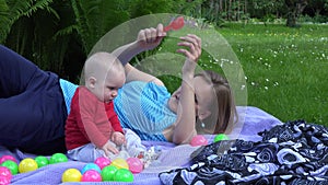 Mother fondle little child and play together outdoor in garden. 4K