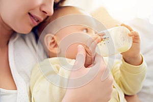 Mother, formula and baby drinking with bottle for nutrition, growth and childhood development at home. Care, infant and