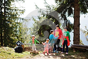 Mother with four kids resting in mountains. Family travel and hiking with childrens