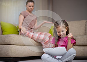 Mother frustrating that her daughter playing video games.