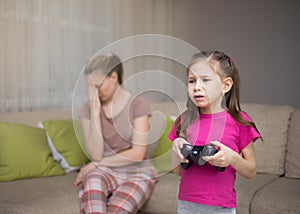 Mother frustrating that her daughter playing video games.