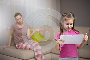 Mother frustrating that her daughter playing video games.