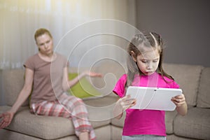 Mother frustrating that her daughter playing video games. photo