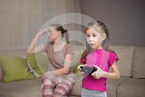 Mother frustrating that her doughter playing video games. photo