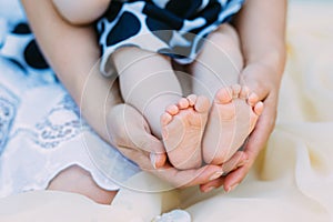 Mother gently hold baby leg in hand. soft focus on babies foot