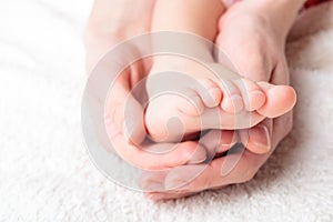 Mother gently hold baby's leg