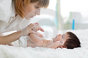 Mother gently massaging her baby`s feet