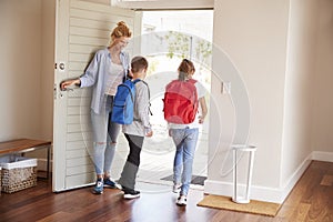 Mother Getting Children Ready To Leave House For School