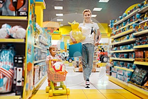 Mother with girl buying a lot of toys in store