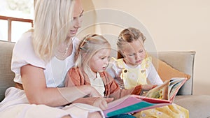 Mother, girl children and book on sofa for reading, learning and development with care, love and bonding. Mom, kids and