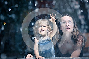 Mother and girl by fountain