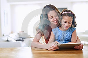 Mother, girl and tablet for games at table, online play and remote learning or education in home. Daughter, mama and