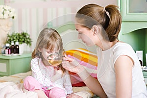 Mother gives to drink to the sick child