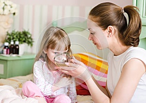 Mother gives to drink to the sick child