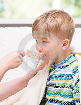 Mother gives to drink to the sick child