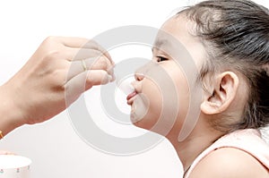 Mother giving baby girl medicine syrup