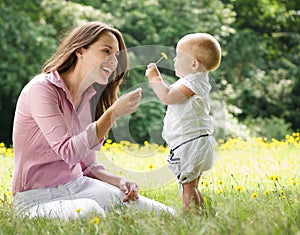 Mother giving child flower in the park