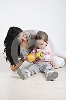 Mother giving fruits to her little baby