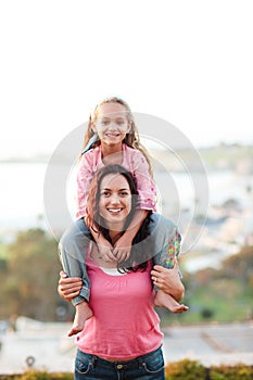 Mother giving her daughter piggyback