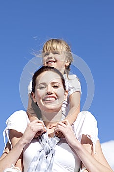 Mother giving her daughter piggyback ride