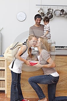 Mother giving her daughter the school lunch