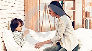 Mother Giving Medicine to Sick Son Lying Bed