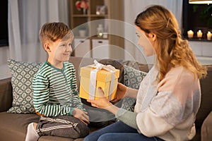 Mother giving present to her little son at home