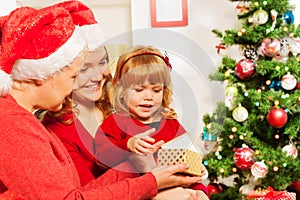 Mother and grandmother giving present to daughter