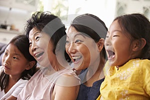 Mother With Grandmother And Granddaughters Watching TV