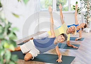 Mother, grandmother and teen son do Vasishthasana, side plank pose