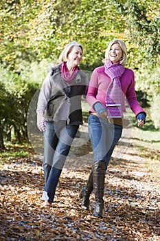 Mother and grown up daughter on walk through woods photo