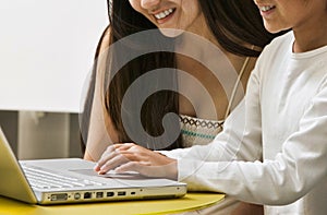 Mother guiding her daughter on online class with the laptop