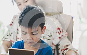 Mother guiding her son to use tablet the right way