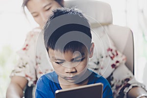 Mother guiding her son to use tablet the right way