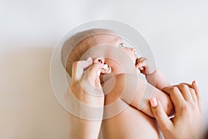 Mother hand cleaning baby ear on towel