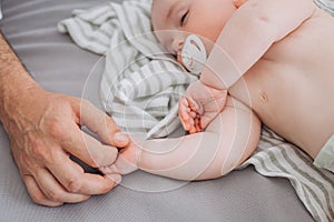 mother hand gently caress sleeping baby bed