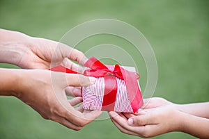 Mother hand giving a gift box to her child.