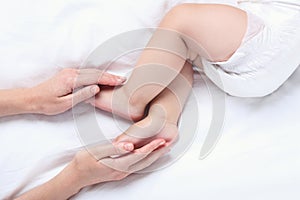 Mother hand holding her baby legs
