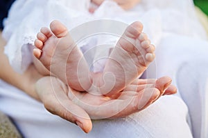 Mother hand holding small baby feet